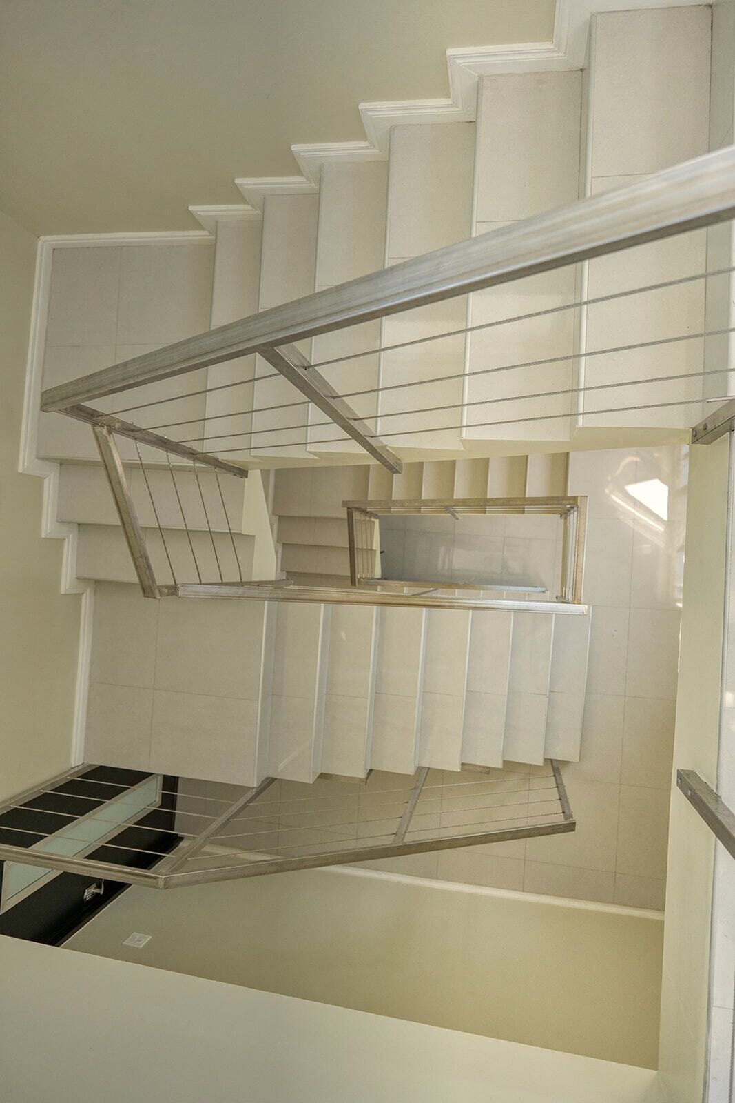 A staircase with a metal railing and a glass panel.