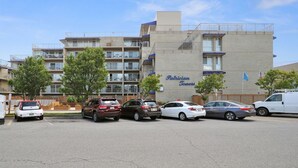 Un estacionamiento con varios coches y un edificio con la leyenda "Patrician Towers".
