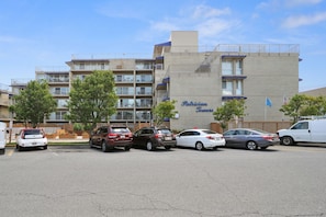 A parking lot with several cars and a building labeled "Patrician Towers".