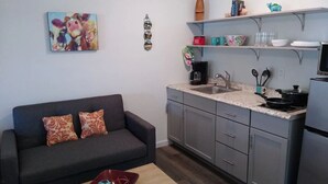 A compact living space with a kitchenette, a sofa, and a coffee table. - Groveport Resort/Waterfront Cabin C/Newly Remodeled (Grove)