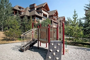 Kids can climb and play on the playground structure with a metal staircase and climbing wall.