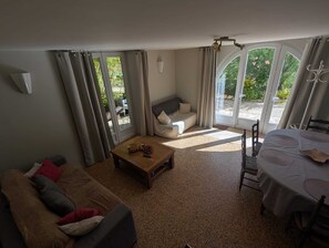 Kodikas olohuone, jossa on sohva, sohvapöytä sekä ruokailutila pöytineen ja tuoleineen.