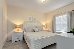 A bedroom with a bed, bedside tables, a desk, and a window with curtains. - Lucaya Village Resort - 4 Bed 3 Bath Townhouse (Kissimmee)