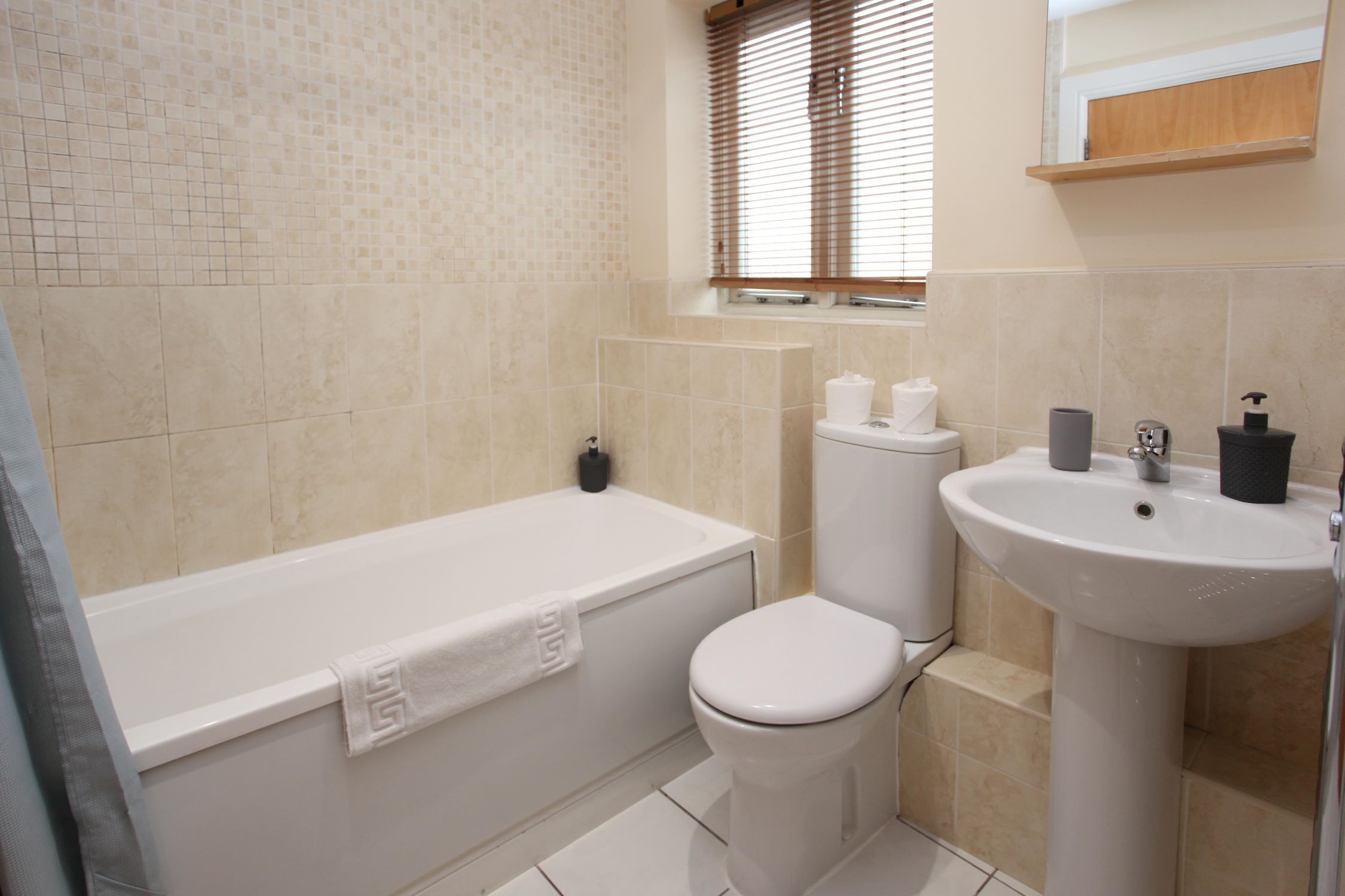 A bathroom with a bathtub, toilet, and sink.