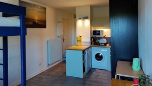 A compact kitchen with a washing machine, a microwave, and a coffee maker. - Oceanfront studio above the pines (Seignosse)