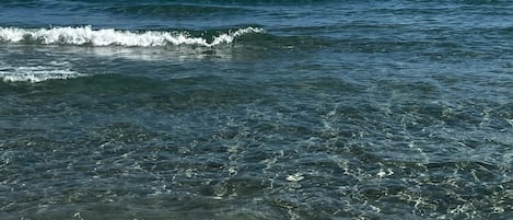 Una playa cerca, sillas reclinables de playa, toallas de playa