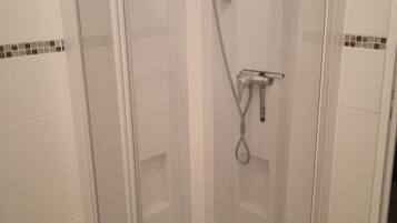 Een douche, een haardroger, handdoeken, toiletpapier