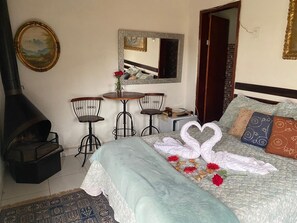 Relax in a traditional room with a plush bed, round table, and fireplace.