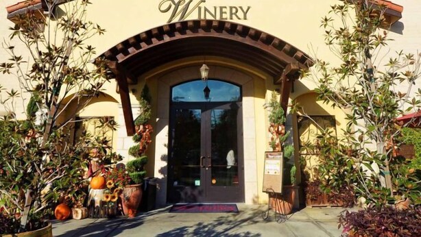 The exterior of San Antonio Winery with a red-tiled roof, arched entrance, and potted plants. - Historic City view   Suites (Los Angeles)