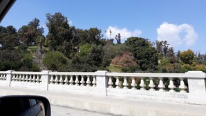 A bridge with a white balustrade and a view of trees and hills in the background. - Historic City view   Suites (Los Angeles)