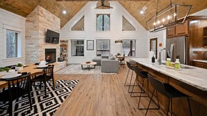 A spacious living area with a fireplace, a dining table, and a kitchen with a large island.