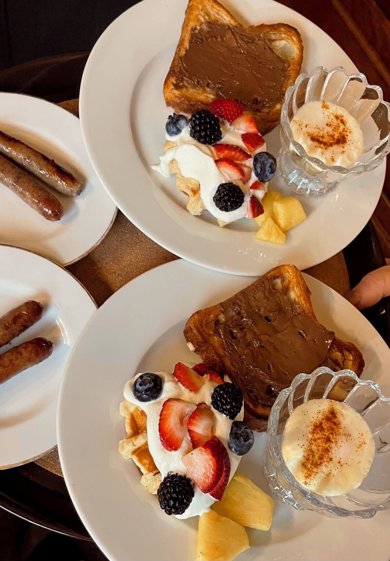 Un desayuno con tostadas, fruta y un vaso pequeño de una bebida blanca.