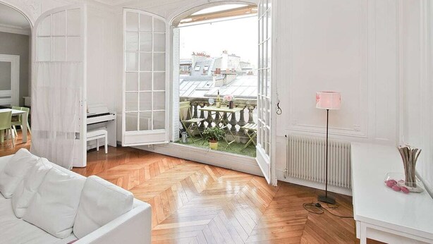 A spacious room with a large open door leading to a balcony, a white sofa, a radiator, and a pink floor lamp. - 200m2 luxury apartment in a secure private alley. Center of Paris (PARIS)