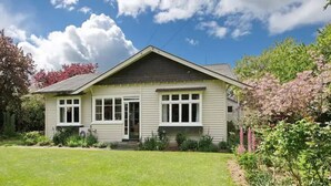 A single-story house with a front porch, a small front yard, and a clear blue sky with clouds. - Family-friendly, well-equipped, spacious country house,garden and Fibre Internet (Ohoka)