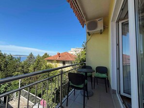 A balcony with a view of a body of water, a red-roofed building, and a Samsung air conditioner. - Holiday apartment mit Meerblick (Dramalj)