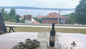 Une table dressée avec une bouteille de vin, des verres et une assiette de collations.