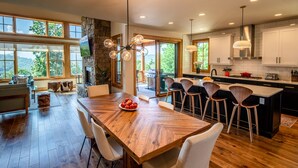 A spacious kitchen with a large island, wooden flooring, and a stone accent wall.