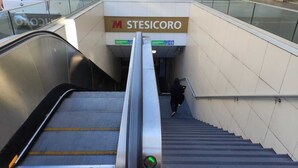 Una escalera mecánica conduce a una escalera con un letrero que dice 'M STESICORO'.