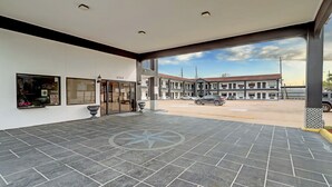 A spacious lobby with a tiled floor, a large window, and a building entrance.