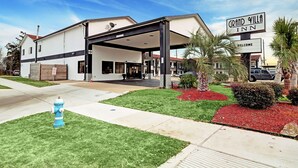 A Grand Villa Inn with a covered entrance, a fire hydrant, and landscaped gardens.