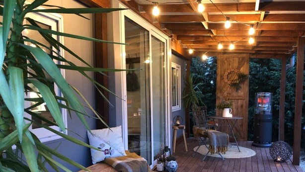 A wooden deck with a bench, a table, and chairs. There are potted plants and a heater. - The Cwtch - Cosy Home, with Breakfast Basket (Little Hartley)