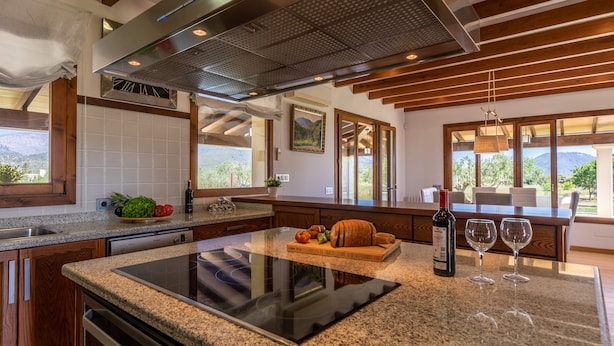 A modern kitchen with a large island, built-in dishwasher, and a view of the outdoors. - Modern finca, secluded location, 10min to the dream beach Playa del Muro, large pool (Búger)