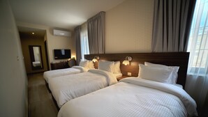 A hotel room with two beds, a TV, and a mirror. - Khan Khediwe Hotel (Amman)