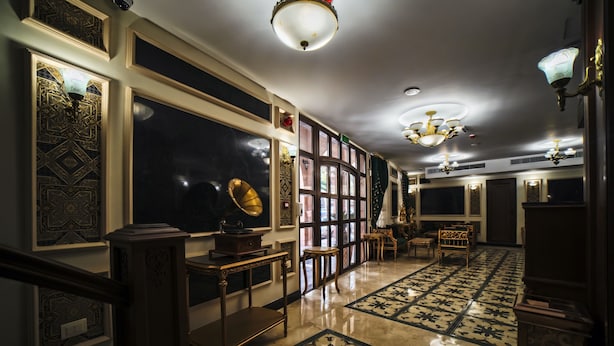 A grand hallway with ornate wall panels, a chandelier, and patterned flooring. - Khan Khediwe Hotel (Amman)