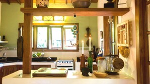 A kitchen with wooden beams, a stove, and various kitchen items on the counter. - Beautiful house with 4 suites and swimming pool in Trancoso (sleeps 10 people) (TRANCOSO)