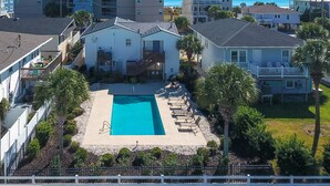Un quartier résidentiel doté d’une piscine, une maison avec un balcon et un immeuble à plusieurs étages.