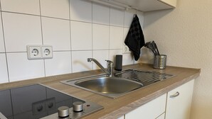 Eine Küche mit Einbauherd, Spüle und einer Holzausziehtischplatte.