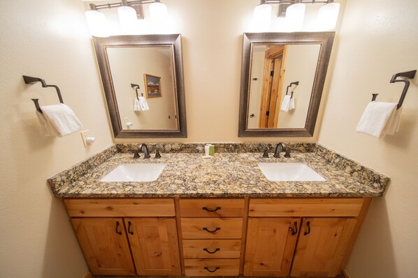 A bathroom with two sinks, wooden cabinets, and a large mirror. - Ground Floor Condo w/ Great Views & Free Shuttle (Keystone)