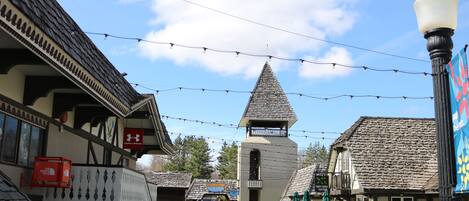 A traditional building with a steeply pitched roof, a bell tower, and a sign for 'Sawmill Services'.