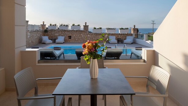 A rooftop terrace with a pool, seating, and a vase of flowers. - Zen play apartment,pool,Near beach & amenities (Nea Magnisia)
