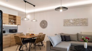 Un espace de vie moderne comprenant un coin repas, un canapé et une table basse.