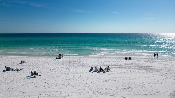 A beach with people sunbathing and sitting on chairs. - MARAVILLA "LUCKY TOO" BEAUTIFUL PRIVATE BEACH VIEWS END UNIT "BEACH SETUP DAILY" (Miramar Beach)