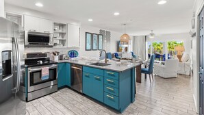 A modern kitchen with stainless steel appliances, teal cabinetry, and a large island with a sink. - MARAVILLA "LUCKY TOO" BEAUTIFUL PRIVATE BEACH VIEWS END UNIT "BEACH SETUP DAILY" (Miramar Beach)