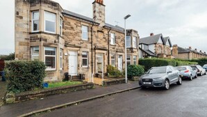A row of terraced houses with a parked car in front. - The Riverside Apartment (free parking) (Stirling)