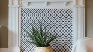 A fireplace with a patterned backdrop, a round mirror with a gold frame, and a hanging light fixture. - The Riverside Apartment (free parking) (Stirling)