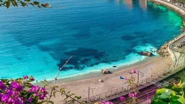 Un poble costaner amb un port esportiu, edificis al front marítim i una zona de platja.
