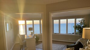 A bedroom with a view of the sea, a desk with a lamp, and a chair. - Sunrise Catcher with a Panoramic View!  (Harpswell)