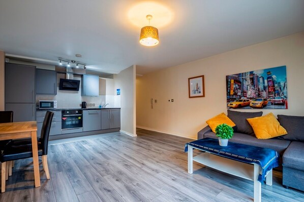 A modern apartment with a kitchen, dining area, and living room.