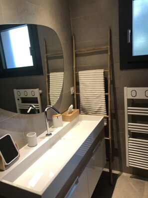 A modern bathroom with a white sink, a mirror, a towel rack, and a wooden ladder. - Detached, air-conditioned villa. Swimming pool. A garden with trees. Near the beaches (San-Gavino-Di-Carbini)