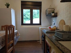 A compact kitchen with a window, a microwave, and a sink.