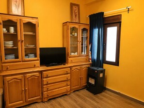 Ein Zimmer mit Holzschnitzereien, einem Flachbildfernseher und einem Heizgerät.