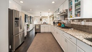 A modern kitchen with stainless steel appliances, white cabinetry, and a granite countertop. - Colorado Mountain Getaway Retreat (Idaho Springs)