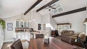 A spacious living area with a dining table, a sofa, and a kitchen in the background. - Colorado Mountain Getaway Retreat (Idaho Springs)