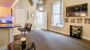 A spacious living area with a ceiling fan, a kitchen area with a sink and cabinets, and a dining table with chairs. - Industrial Chic Loft in the Heart of Downtown Richmond! (Richmond)