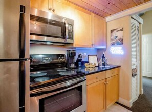 Fully equipped kitchen with refrigerator, microwave, oven, and stovetop.