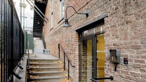 A brick building with a staircase leading to a door labeled "The Corner Loft." - Industrial Chic Loft in the Heart of Downtown Richmond! (Richmond)